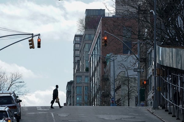A man wearing a protective mask crosses Lexington Avenue in Spanish Harlem during the outbreak of the coronavirus disease (COVID-19) in New York City, New York, U.S., April 15, 2020. REUTERS/Bryan R Smith - RC295G9H435R