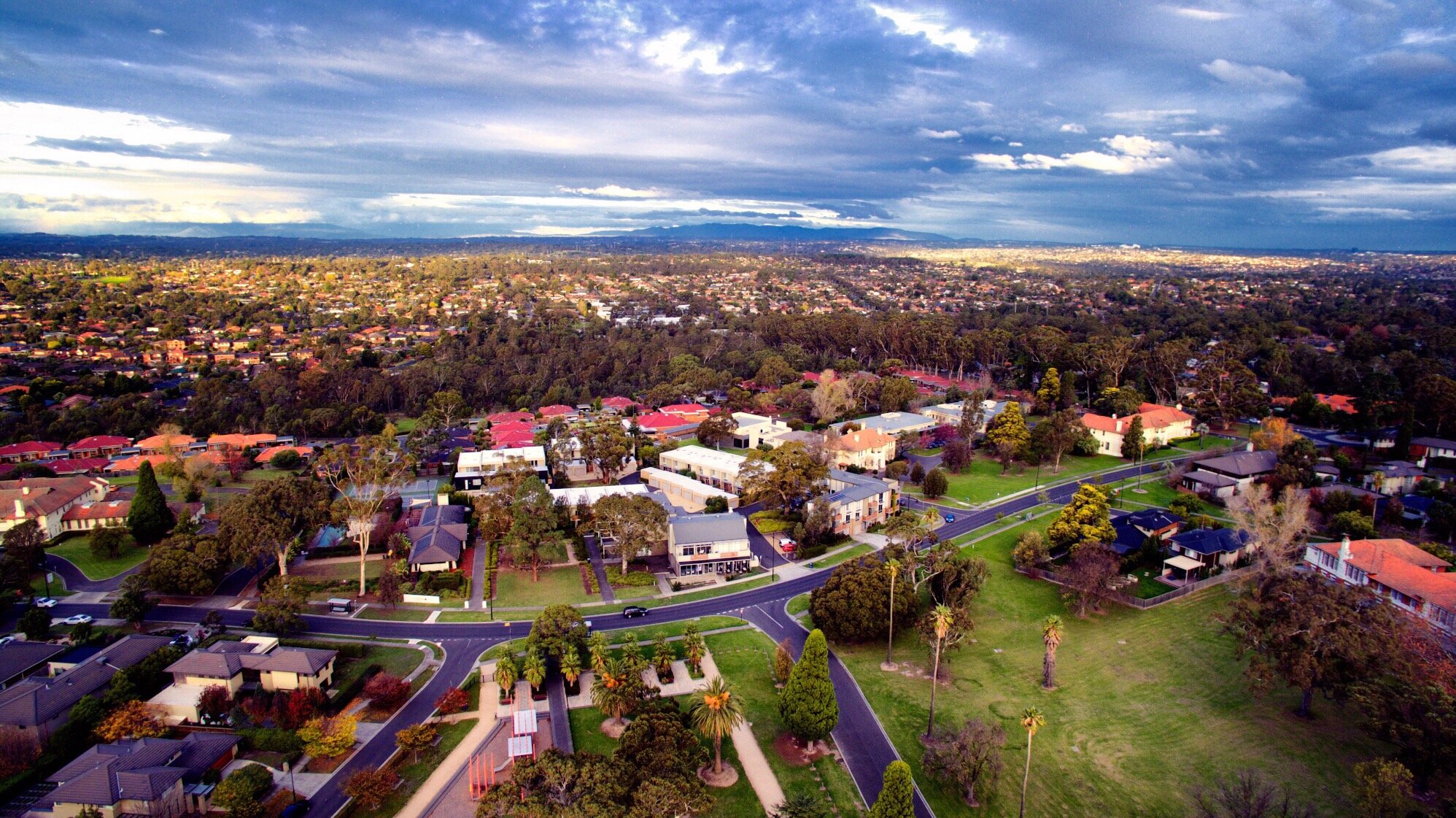 view of a sprawling suburban neighborhood with greenery and blue skies