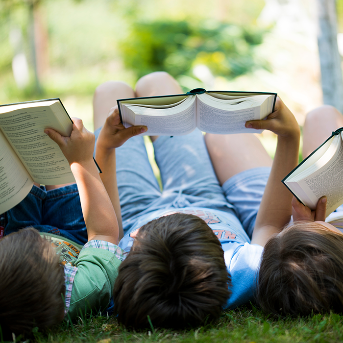 Three children reading in the garden