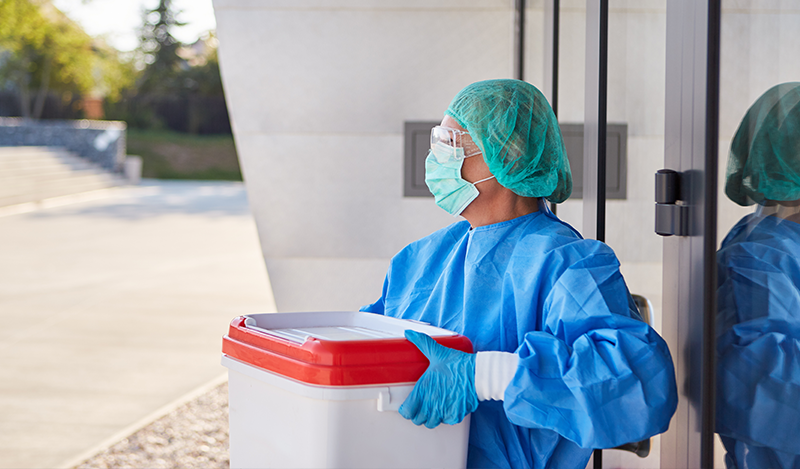 A nurse awaits a medivac while holding a container with a human organ for donation