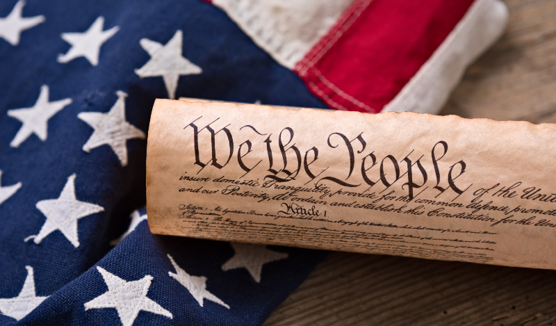 Close up of American Constitution with flag backgroun