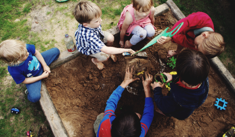 a group of children play in a sandbox at recess. Used for What it will take for social and emotional learning to succeed