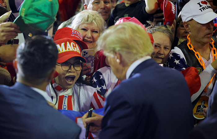 Donald Trump signs and autograph during a campaign event in Manchester, New Hampshire, U.S., April 27, 2023. REUTERS